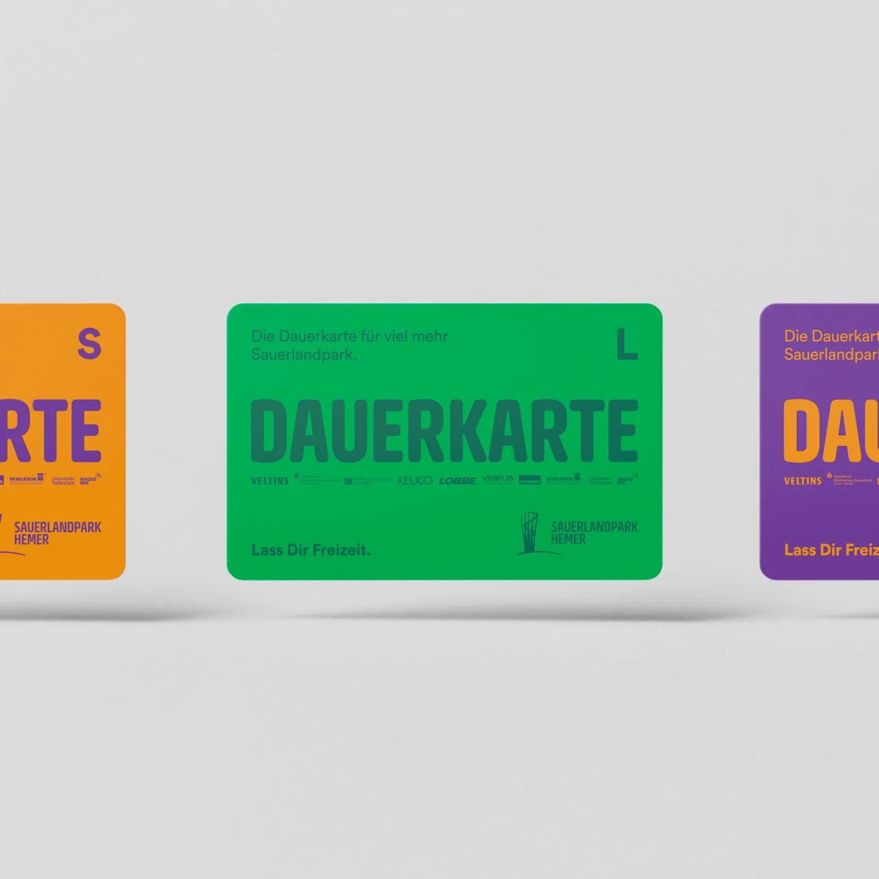 Drei farbige Dauerkarten des Sauerlandparks in Orange, Grün und Lila nebeneinander auf weißem Hintergrund