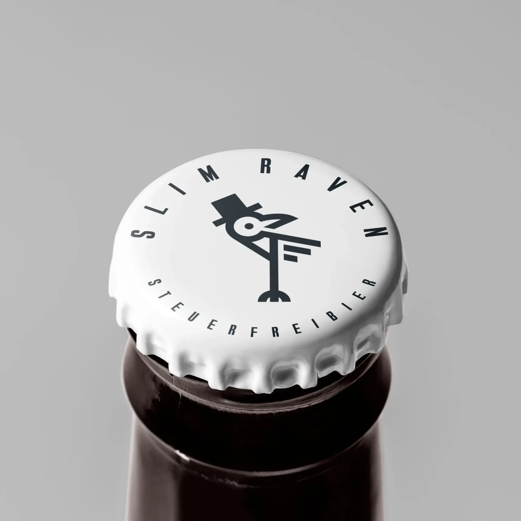 Weißer Kronkorken mit Raben-Logo und Schriftzug „SLIM RAVEN – STEUERFREIBIER“ auf brauner Flasche