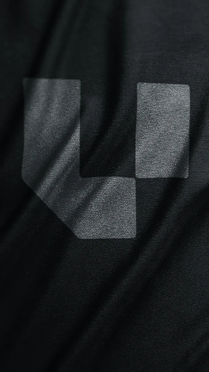 Nahaufnahme eines grauen geometrischen Symbols auf schwarzem, gefaltetem Stoff