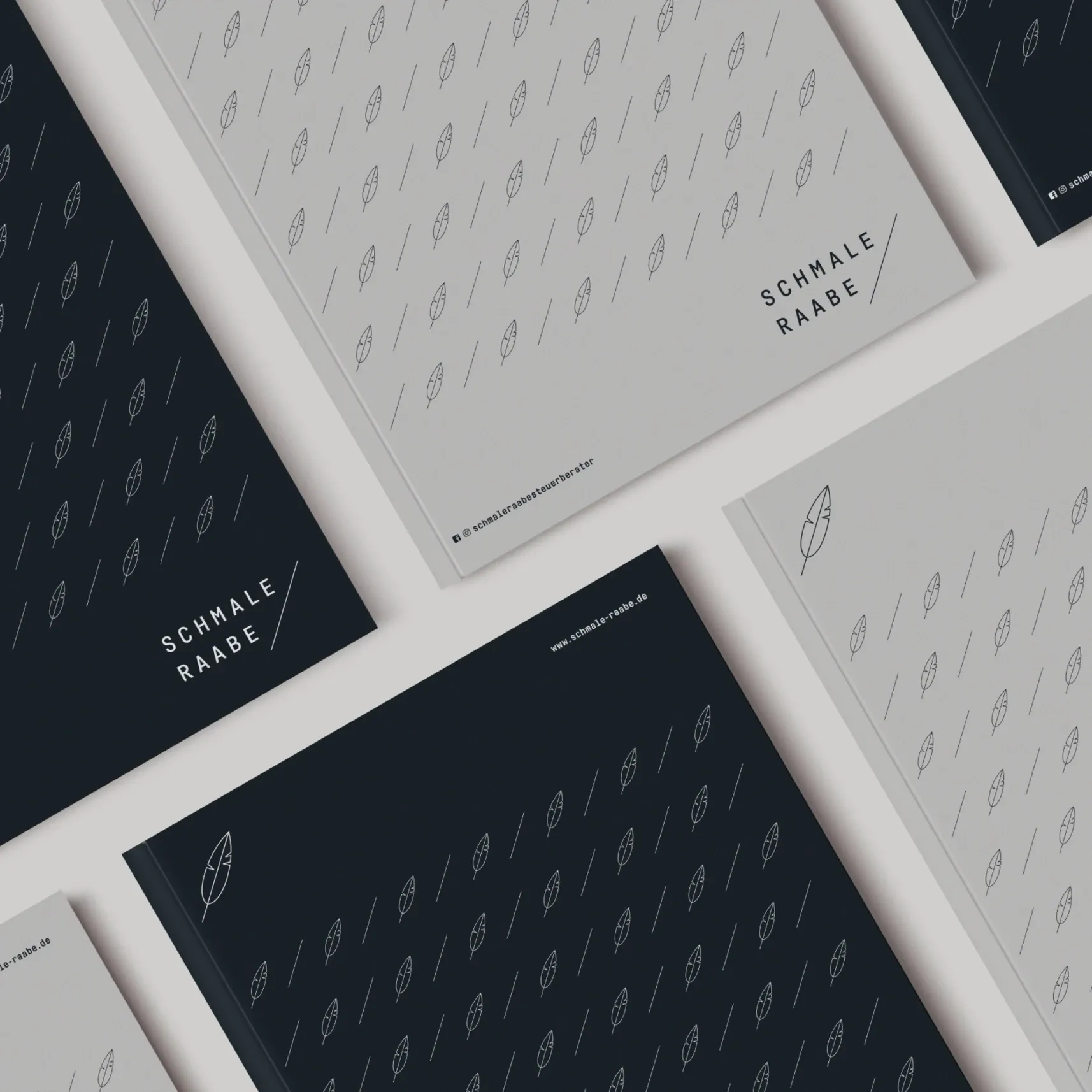Mehrere flachliegende Cover in Hellgrau und Dunkelblau mit Feder-Muster und dem Schriftzug 'SCHMALE RABE'