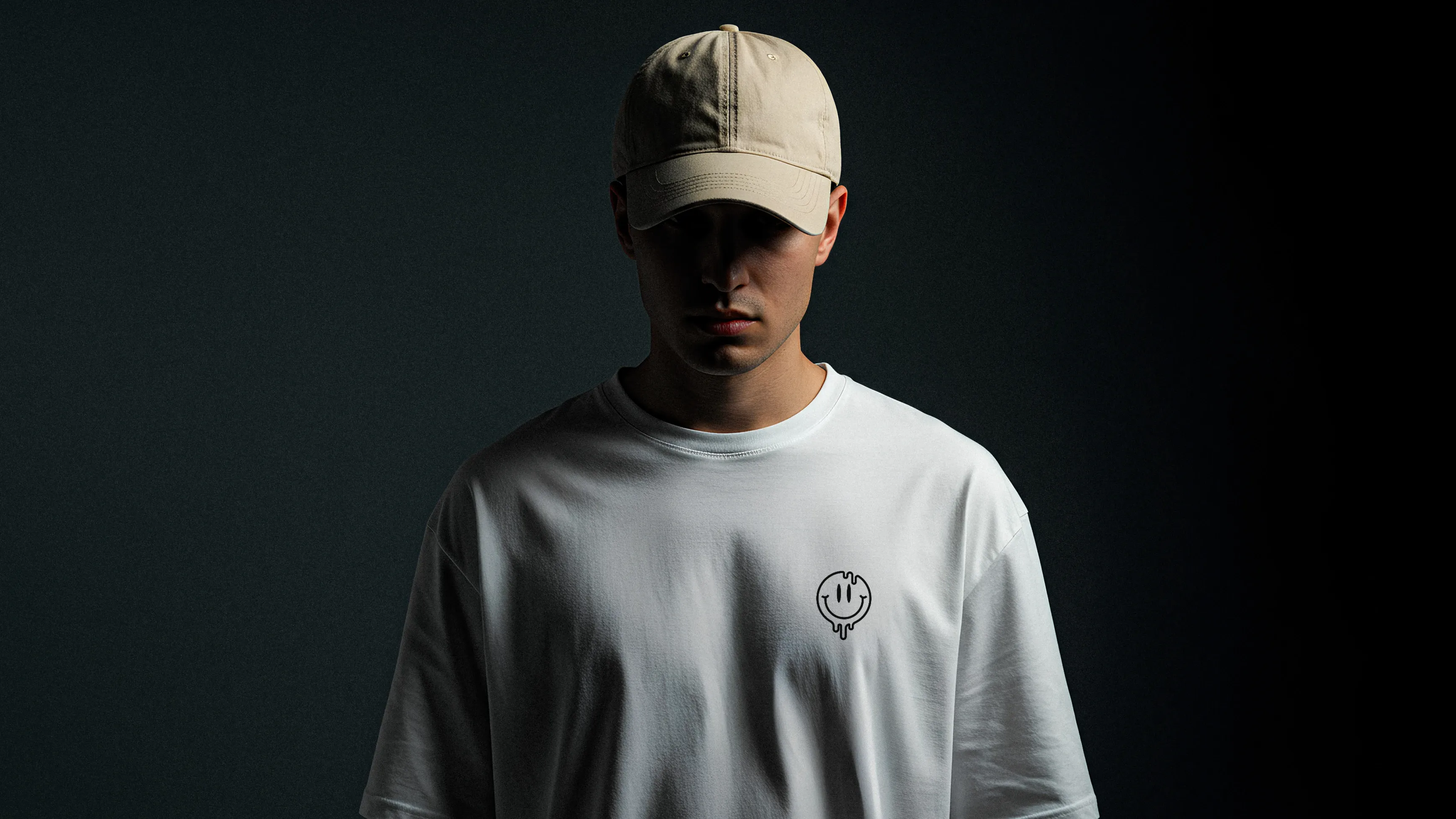 Person mit beigefarbener Kappe und weißem T‑Shirt, Gesicht im Schatten