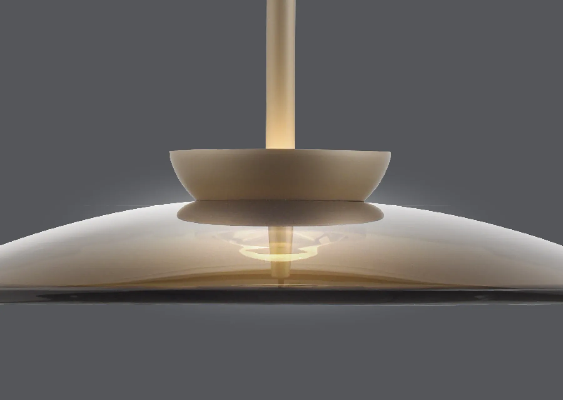 Nahaufnahme einer modernen Pendelleuchte mit flachem, gläsernem Schirm und warmem Licht