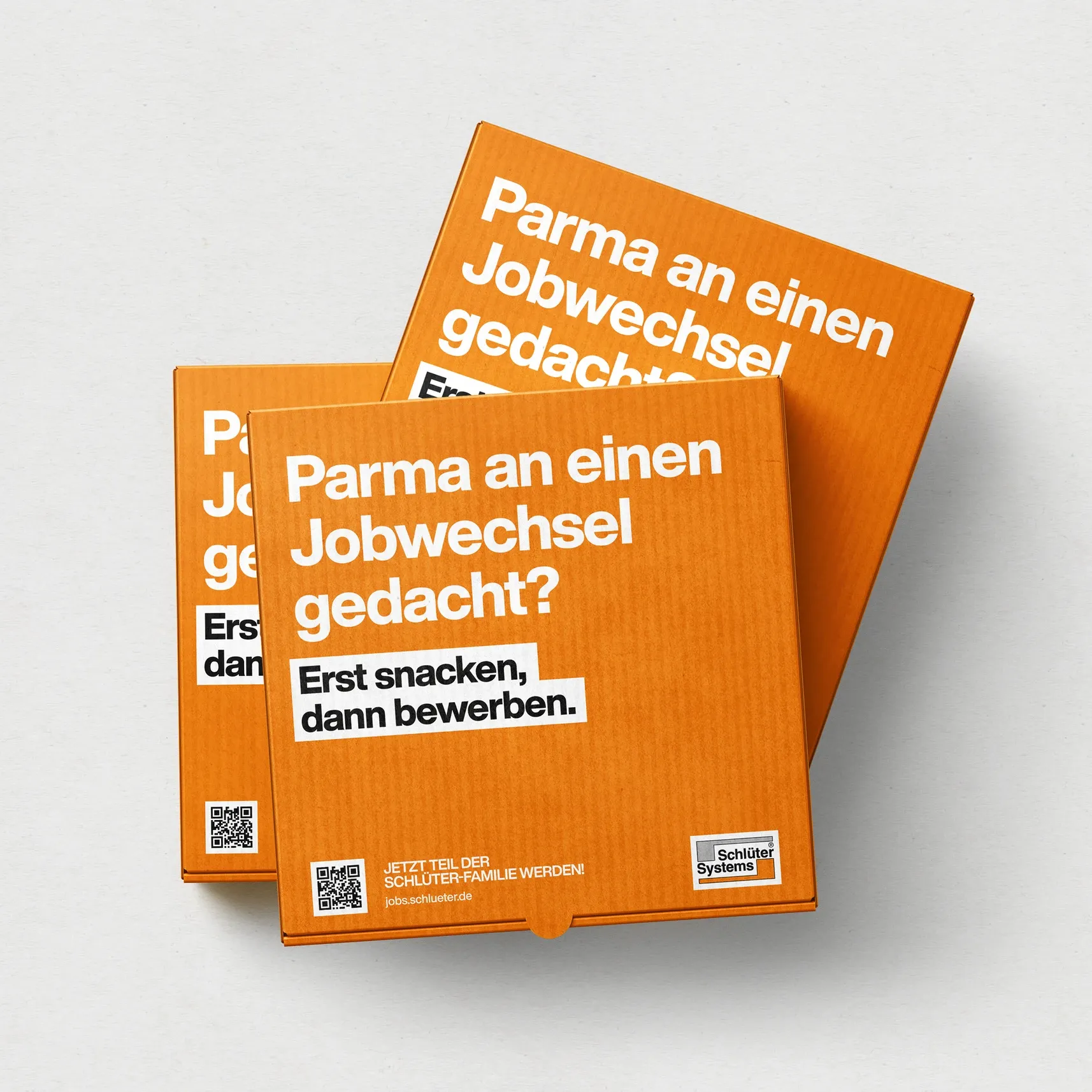 Drei orange Pizzakartons mit weißer Aufschrift „Parma an einen Jobwechsel gedacht? Erst snacken, dann bewerben“