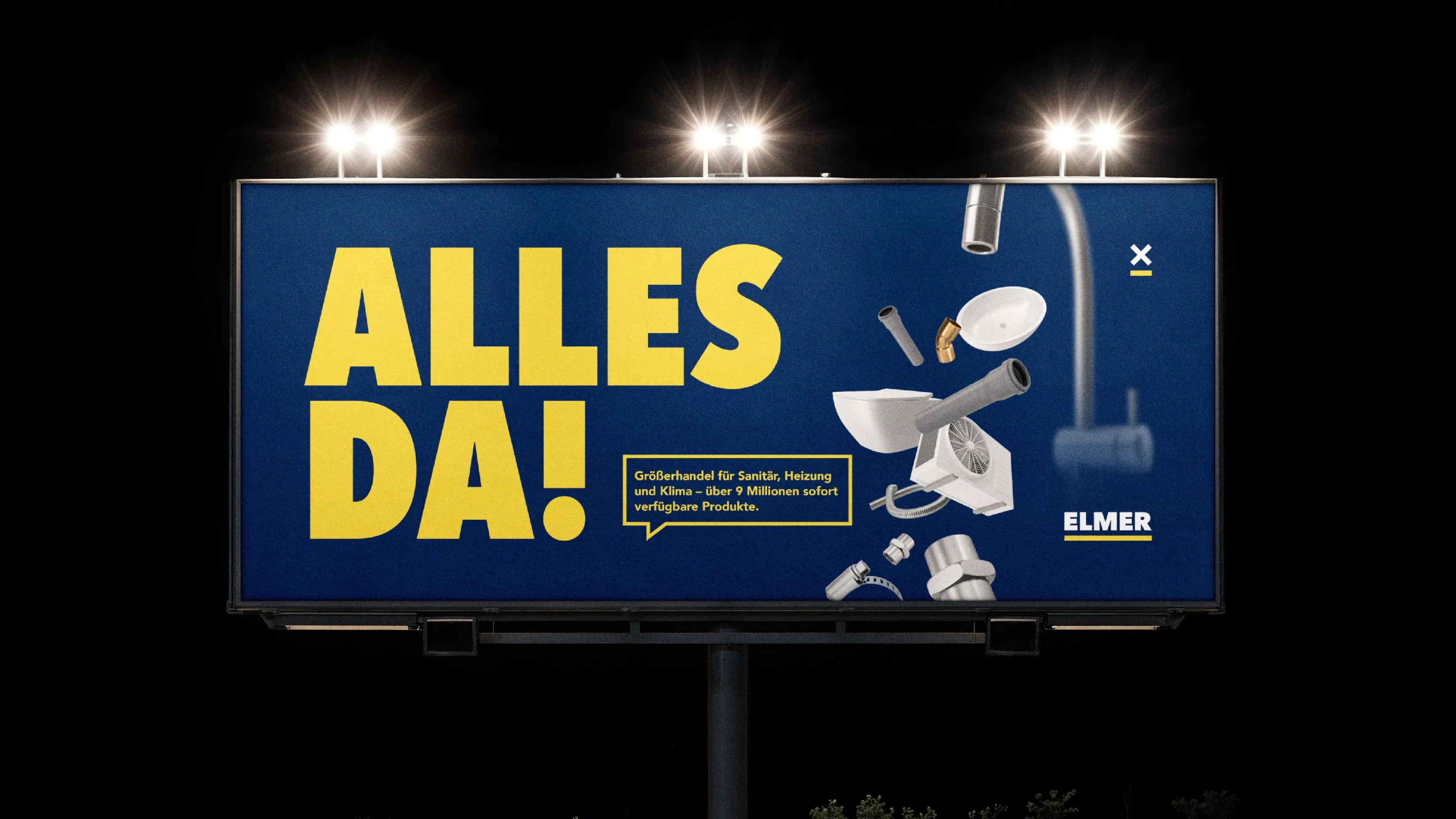 Nachts beleuchtetes Billboard mit gelber Aufschrift „ALLES DA!“ und Sanitärteilen (Toilette, Armatur, Rohre), Marke Elmer