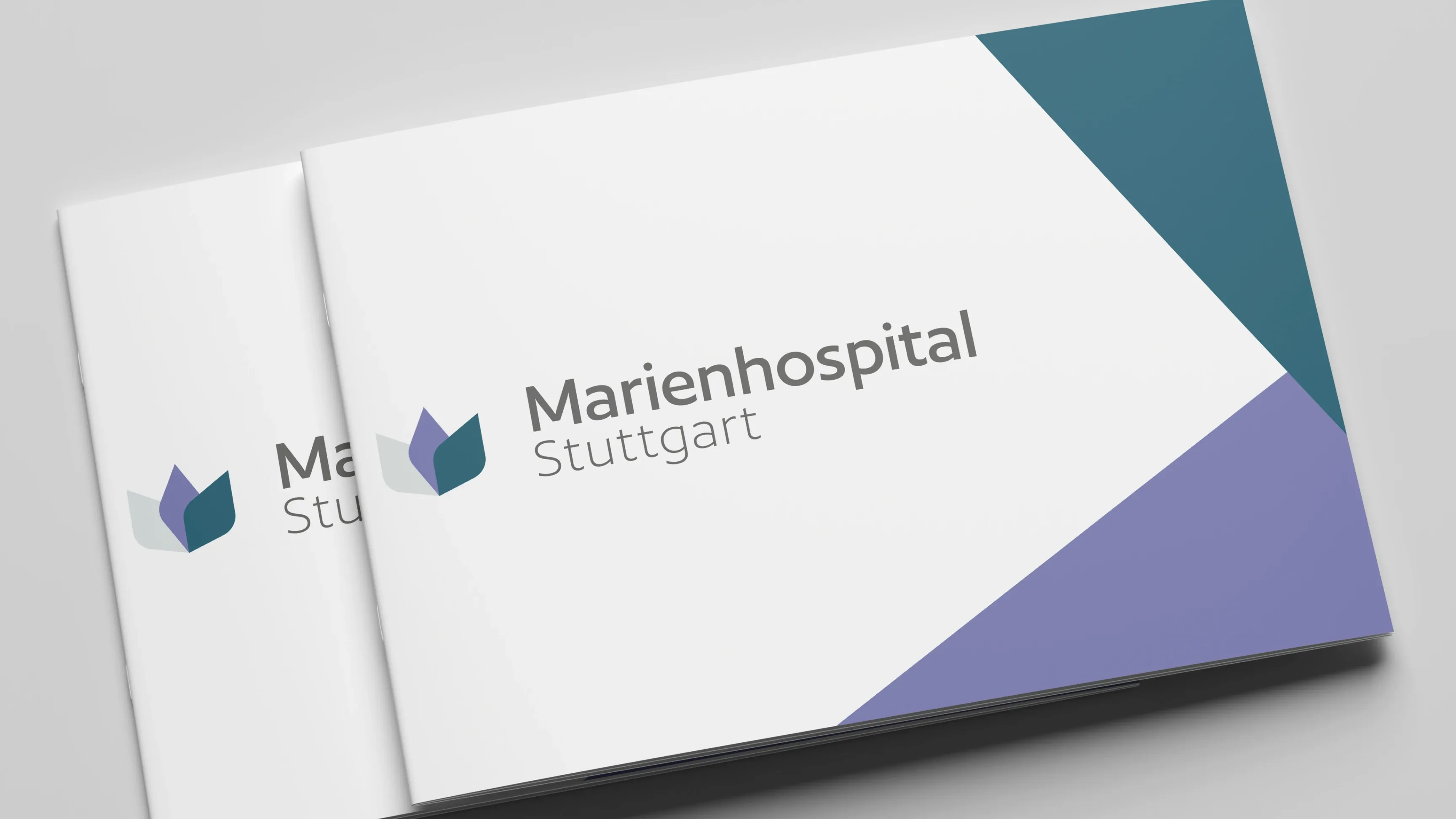 Zwei Broschüren mit Logo und Schriftzug Marienhospital Stuttgart auf weißem Cover mit türkis- und lilafarbenen Formen