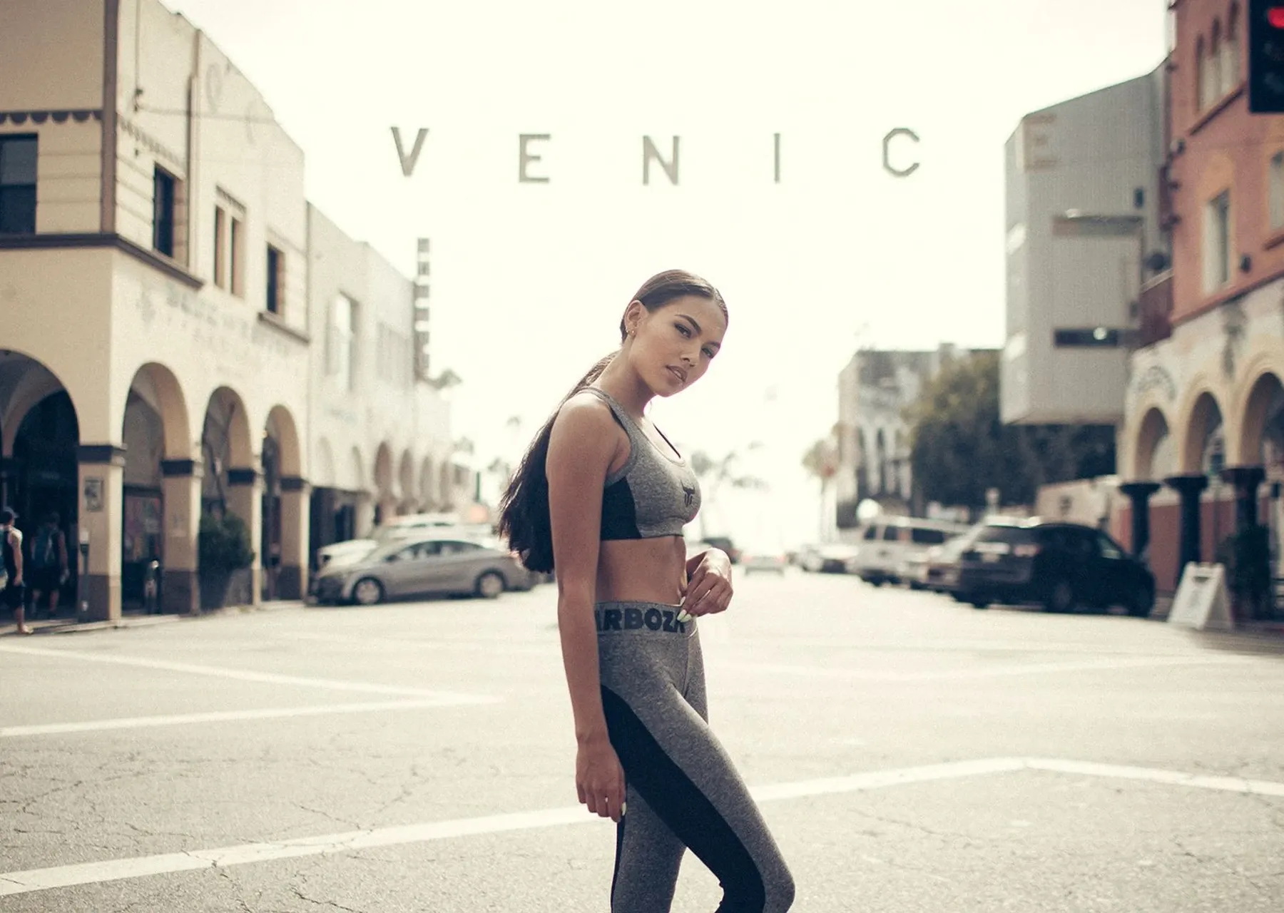 Weibliches Testimonial in Barboza Trainingskleidung steht auf der Straße vor dem Schriftzug Venice
