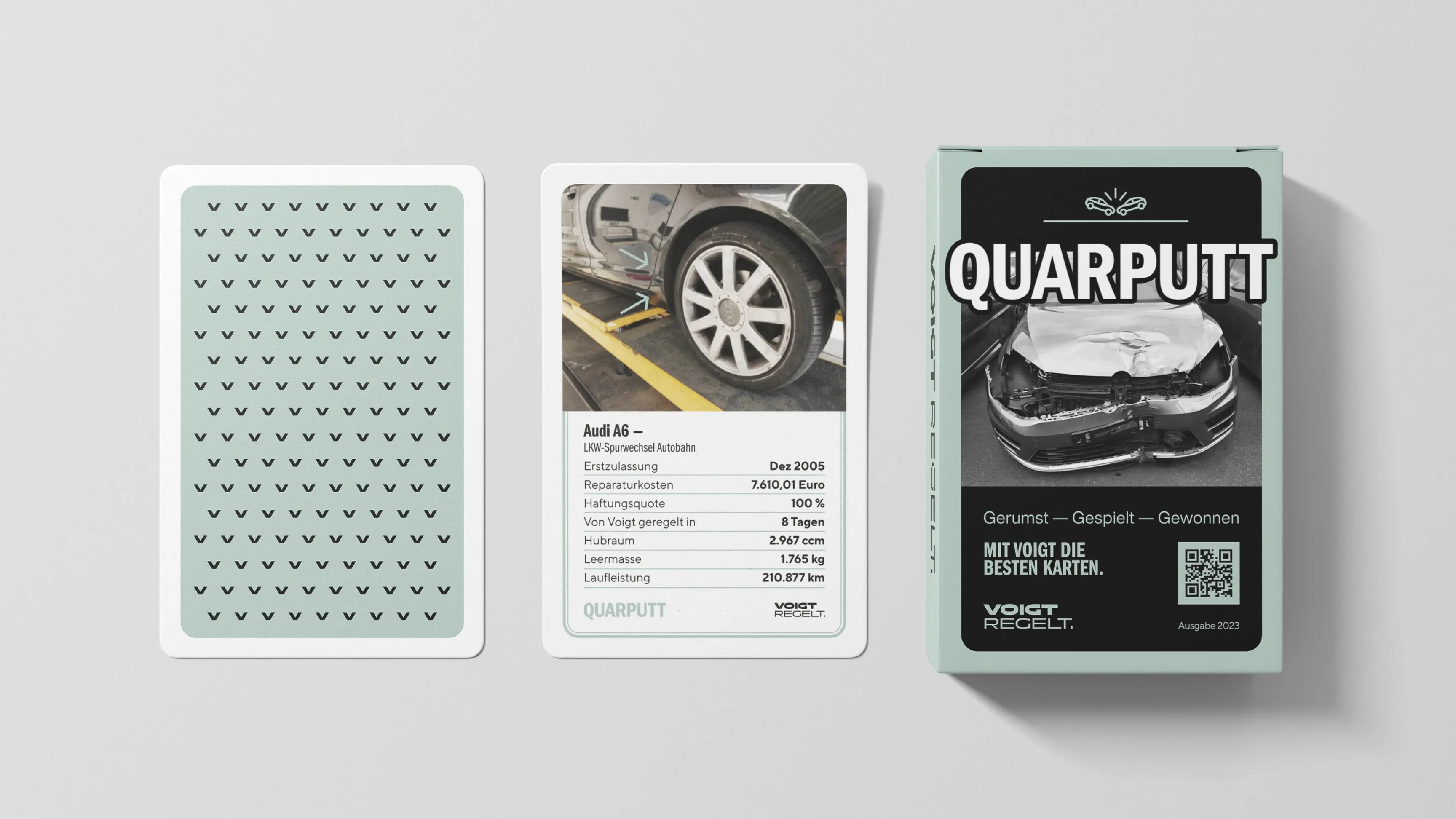 Kartenspiel „QUARPUTT“: Schachtel und zwei Karten, Vorderseite mit Foto eines beschädigten Autos und Daten, Rückseite mintgrün mit Muster