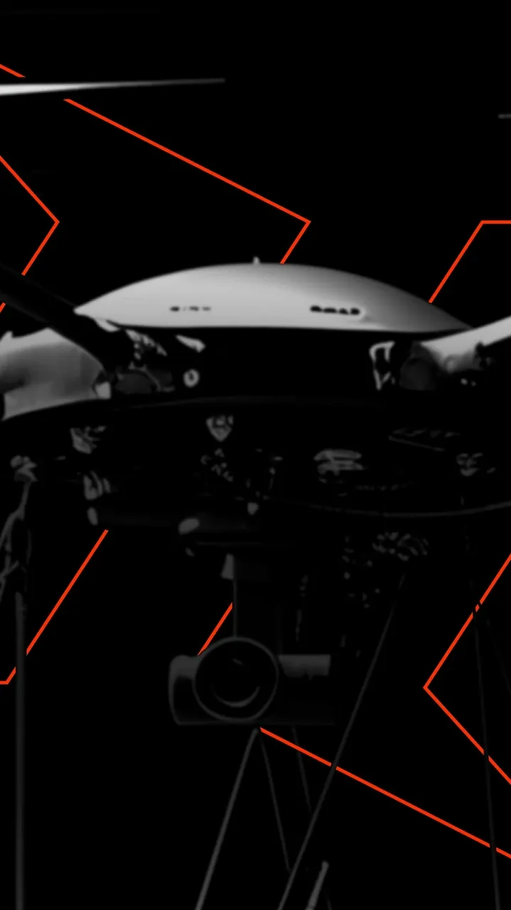 Nahaufnahme einer Kamera-Drohne vor schwarzem Hintergrund mit roten Linien