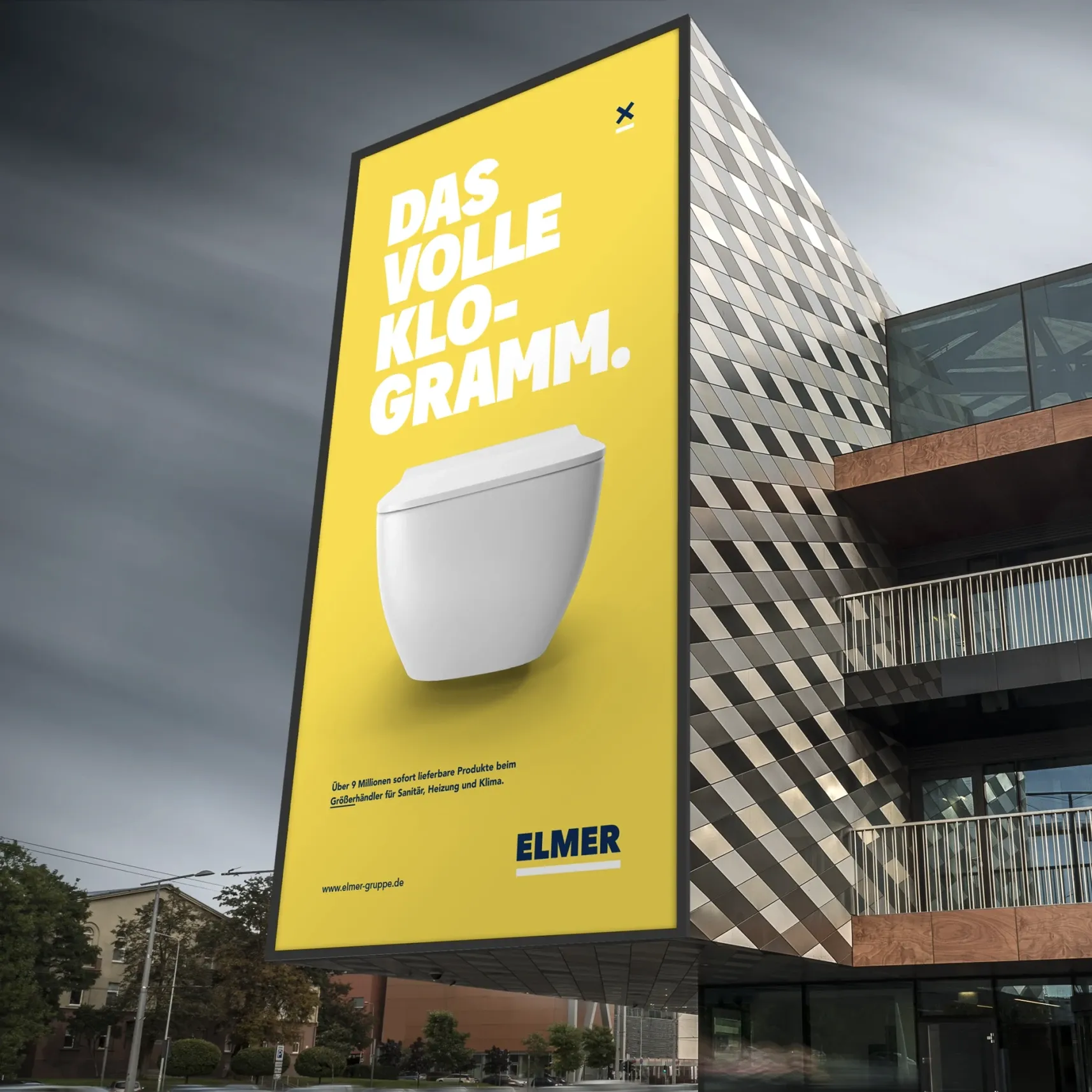 Großes gelbes Werbeplakat an moderner Gebäudeecke mit weißem WC und Text „DAS VOLLE KLO-GRAMM“ (ELMER)