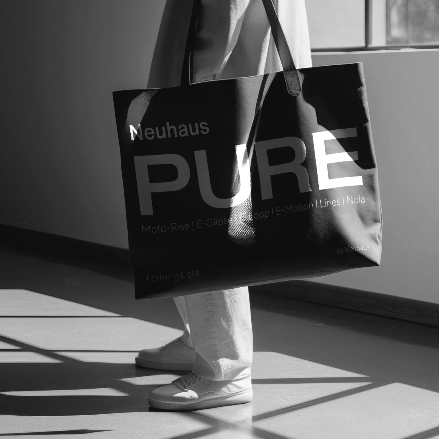Schwarz‑weiß: Person trägt große Tragetasche mit Aufdruck 'Neuhaus PURE' in sonnigem Flur