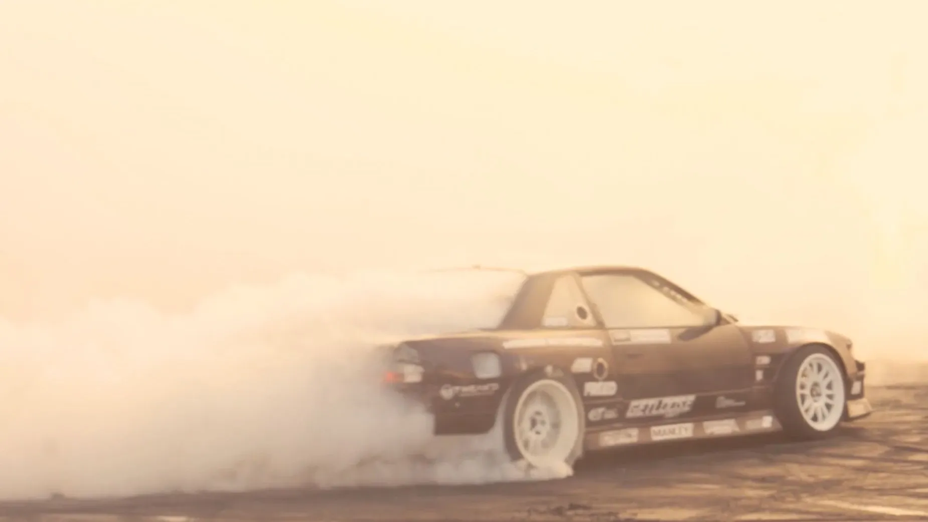 Driftendes Auto wirbelt dichten Reifenqualm auf