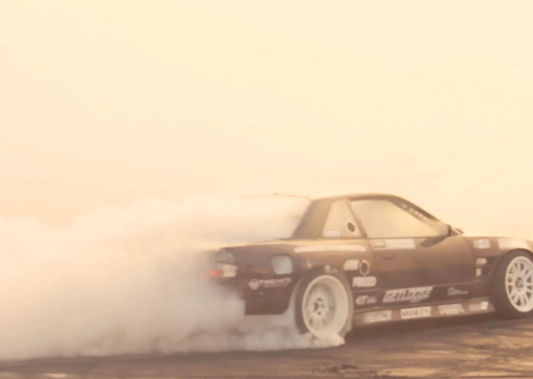 Driftendes Auto wirbelt dichten Reifenqualm auf