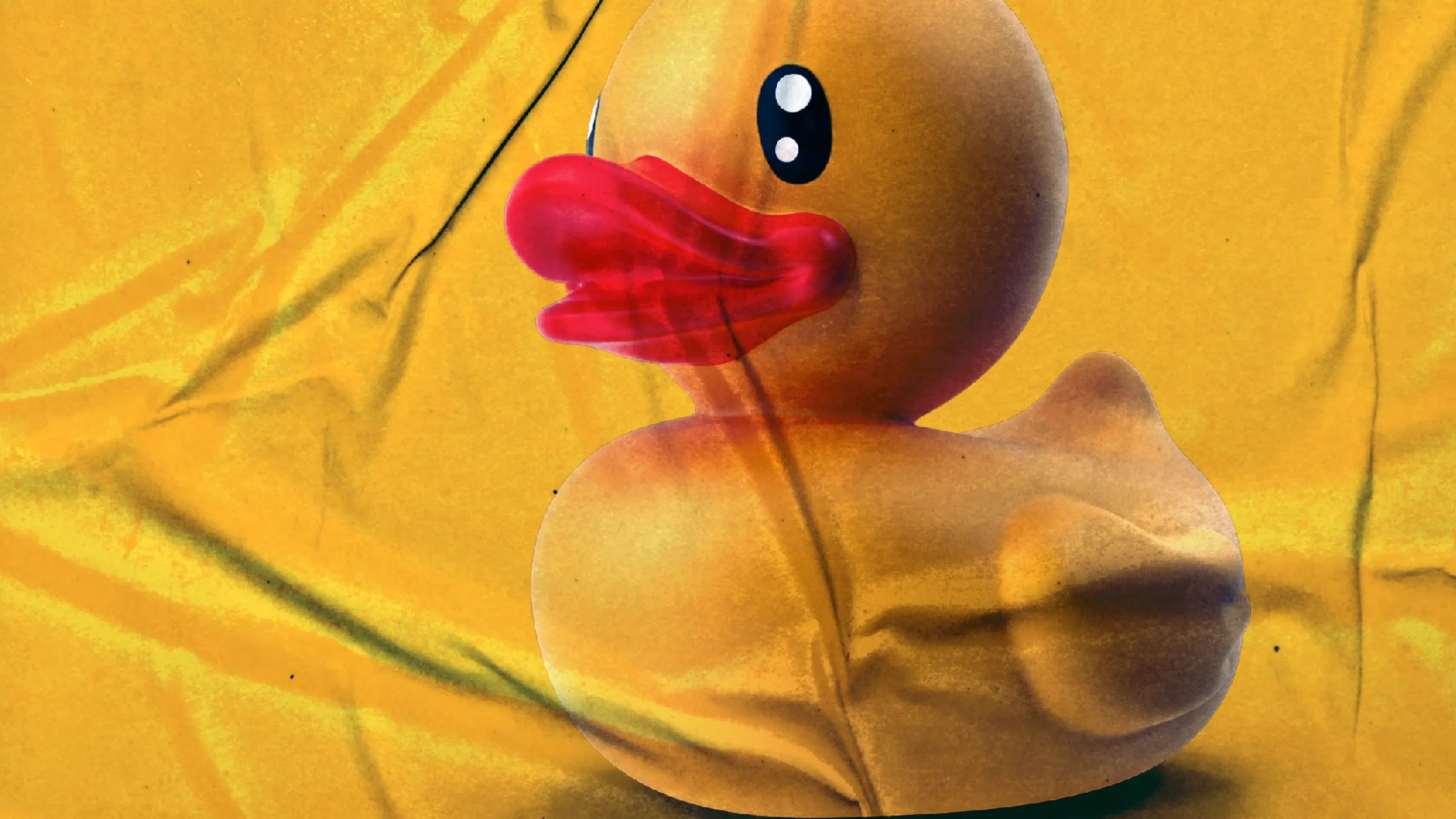 Gelbe Gummiente mit rotem Schnabel auf zerknittertem gelben Hintergrund