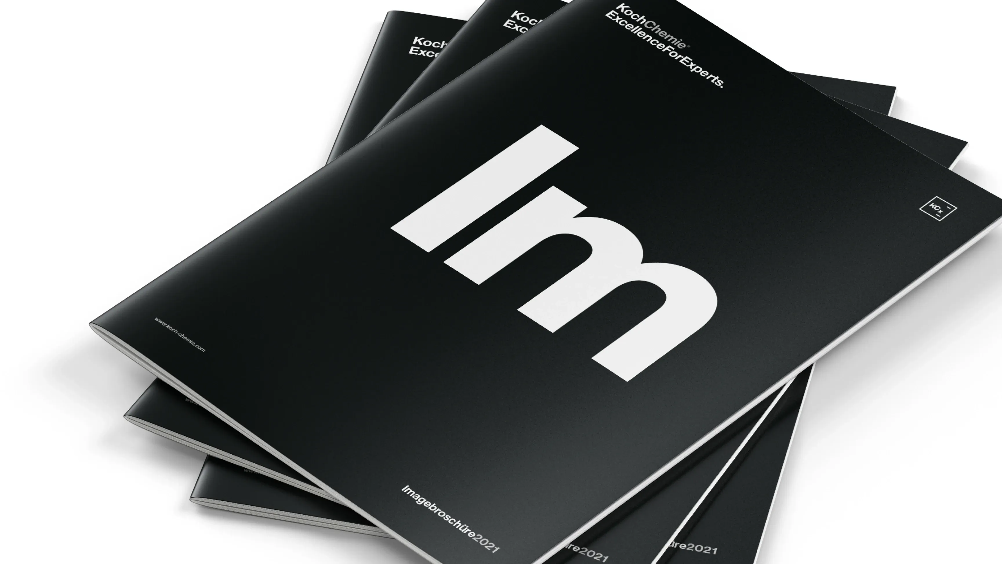 Gestapelte schwarze Magazine mit großem weißen „Im“ auf dem Titel